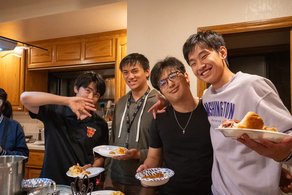 Klesis students smiling with plates of food at Friendsgiving