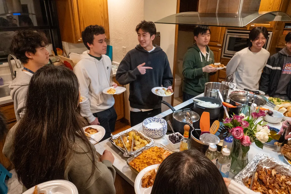 Klesis students gathered around the kitchen at a Friendsgiving dinner