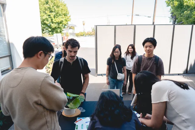Students gathered around an outdoor welcome table