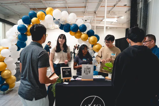 Students checking in at the SVC welcome table under a balloon arch