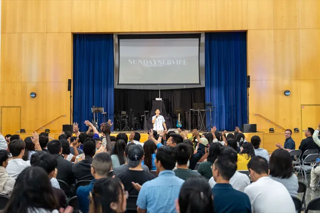 Students worshiping with hands raised during Sunday service